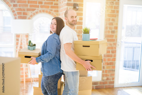 Young couple moving to a new home, smiling happy holding cardboard boxes © Krakenimages.com