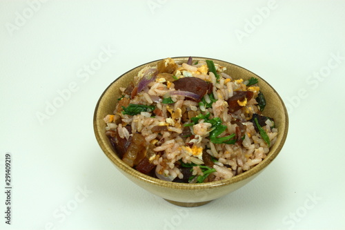 Chinese traditional fried rice with pork and fresh vegetable on the yellow bowl.