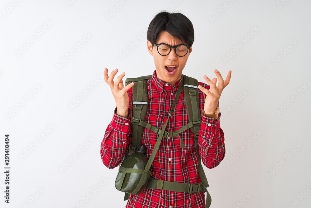 Chinese hiker man wearing backpack canteen glasses over isolated white background celebrating mad and crazy for success with arms raised and closed eyes screaming excited. Winner concept Chinese hiker man wearing backpack canteen glasses over isolated white background celebrating mad and crazy for success with arms raised and closed eyes screaming excited. Winner concept