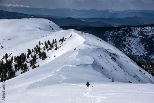 Irkutsk region, Russia, Slyudyanka - April 13, 2019: Silhouette of man are hiking in the mountain and snow back view photo