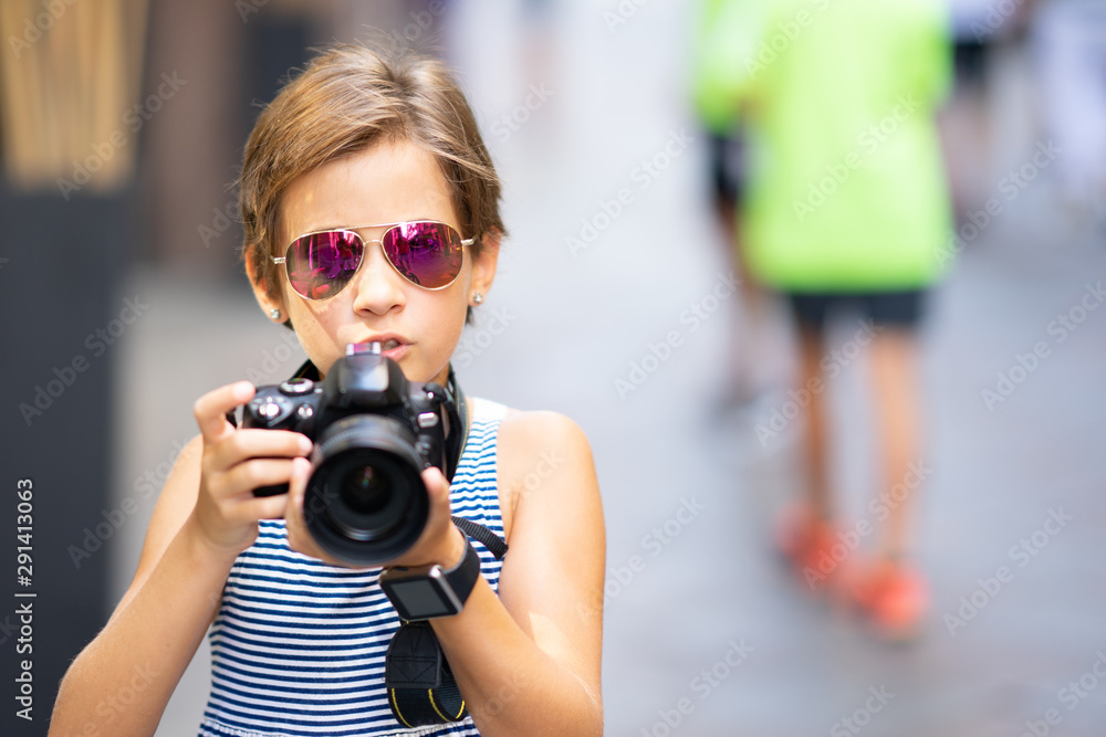 Little girl making photo with DSLR camera on city street Little girl making photo with DSLR camera on city street