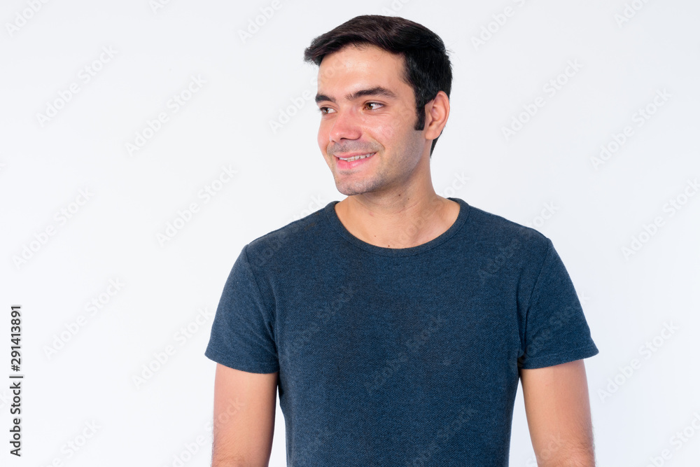 Face of happy young handsome Persian man thinking and looking away Face of happy young handsome Persian man thinking and looking away