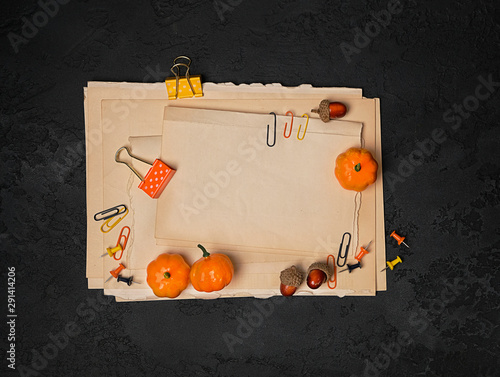 Autumn composition with paper clipboard mockup and stationery, acorns, orange pumpkin on black color background. fall seadon. Creative autumn idea, thanksgiving and halloween holiday concept. Top view photo