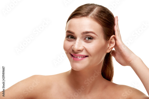 Attractive smiling woman touching her healthy shiny hair