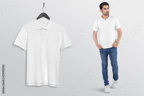 Hanging white plain polo t shirt on wall along with male model in blue denim jeans pant. Isolated background