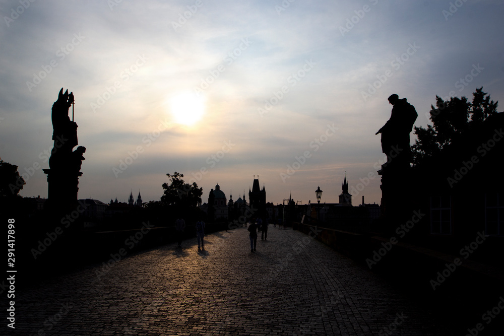 Obraz premium Silhouettes Charles Bridge, Old Town Tower, statues and happy tourists at sunrise, Prague, Czech Republic