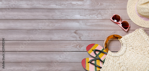 Flat lay composition with beach bag and accessories on wooden background, space for text