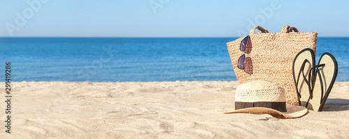 Stylish beach accessories on sandy sea shore. Banner design photo
