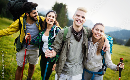 Four happy friends are looking on mountains and having fun together