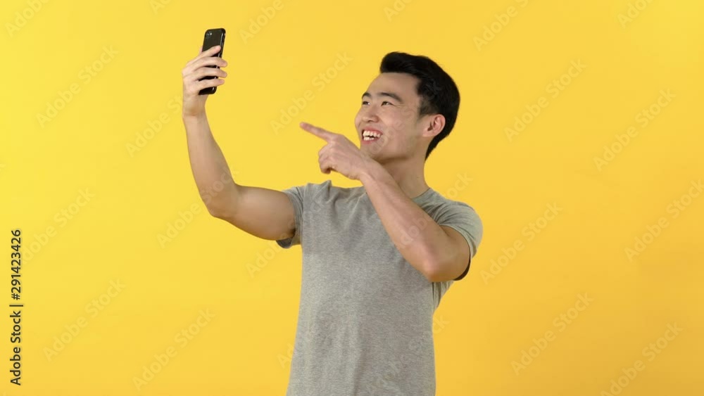 Happy Asian man making video call on smartphone Happy Asian man making video call on smartphone