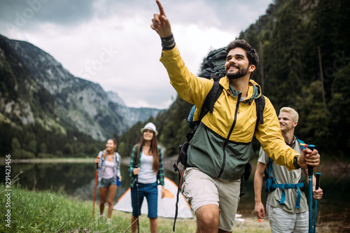 Group of happy friends with backpacks hiking together photo