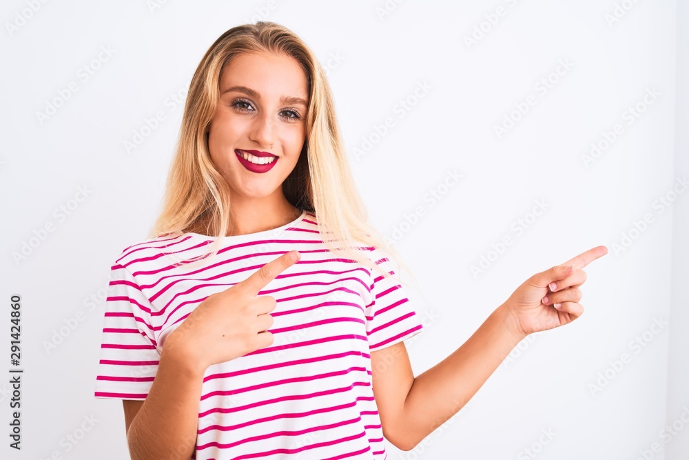 Young beautiful woman wearing pink striped t-shirt standing over isolated white background smiling and looking at the camera pointing with two hands and fingers to the side. Young beautiful woman wearing pink striped t-shirt standing over isolated white background smiling and looking at the camera pointing with two hands and fingers to the side.