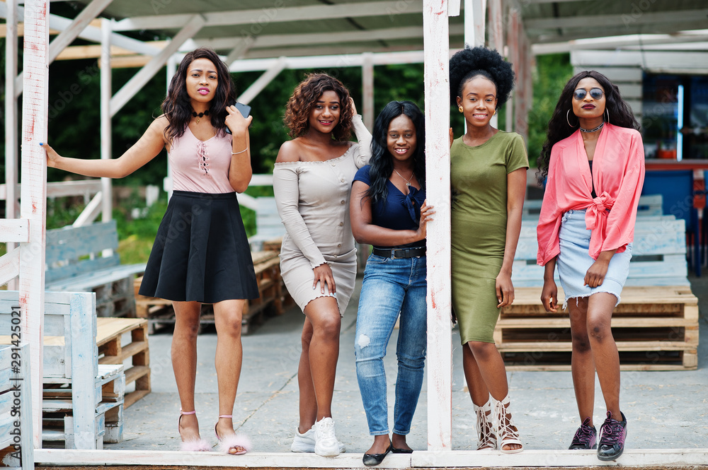 Obraz premium Group of five african american girls relaxing at beach outside cafe.