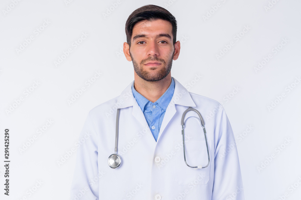 Face of young bearded Persian man doctor looking at camera