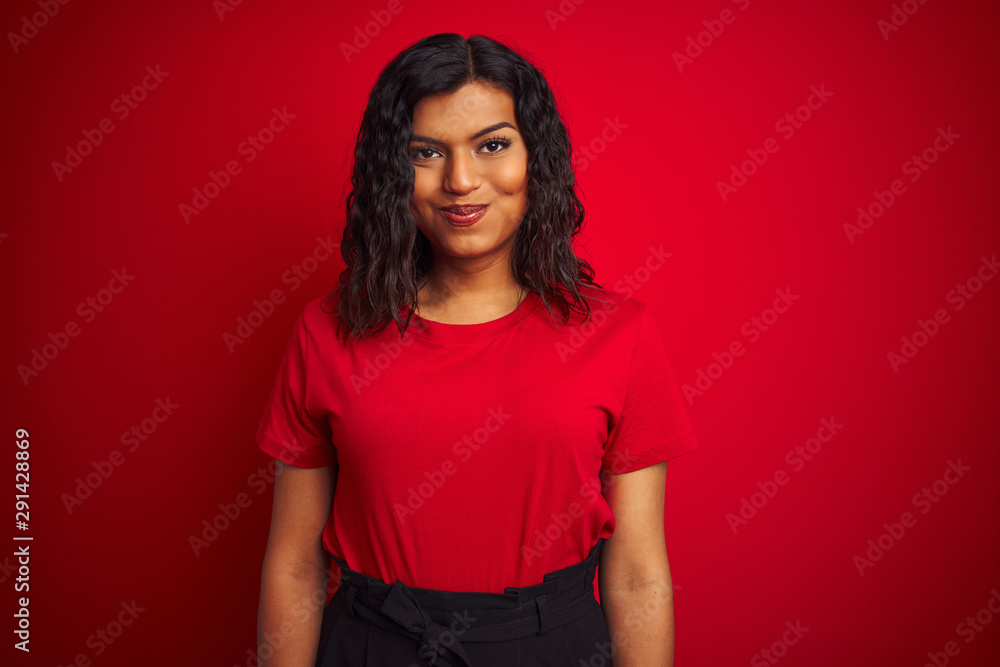 Beautiful transsexual transgender woman wearing t-shirt over isolated red background puffing cheeks with funny face. Mouth inflated with air, crazy expression. Beautiful transsexual transgender woman wearing t-shirt over isolated red background puffing cheeks with funny face. Mouth inflated with air, crazy expression.