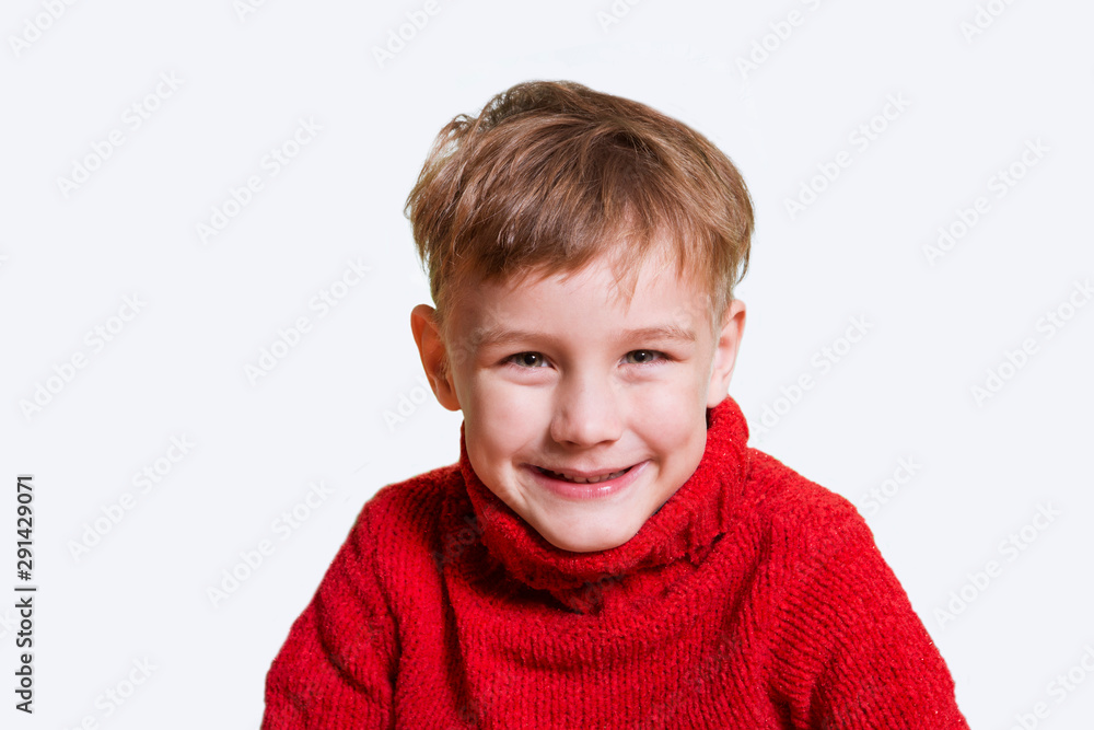 Happy child in a red sweater poses on a white background. Christmas sales. Happy child in a red sweater poses on a white background. Christmas sales.