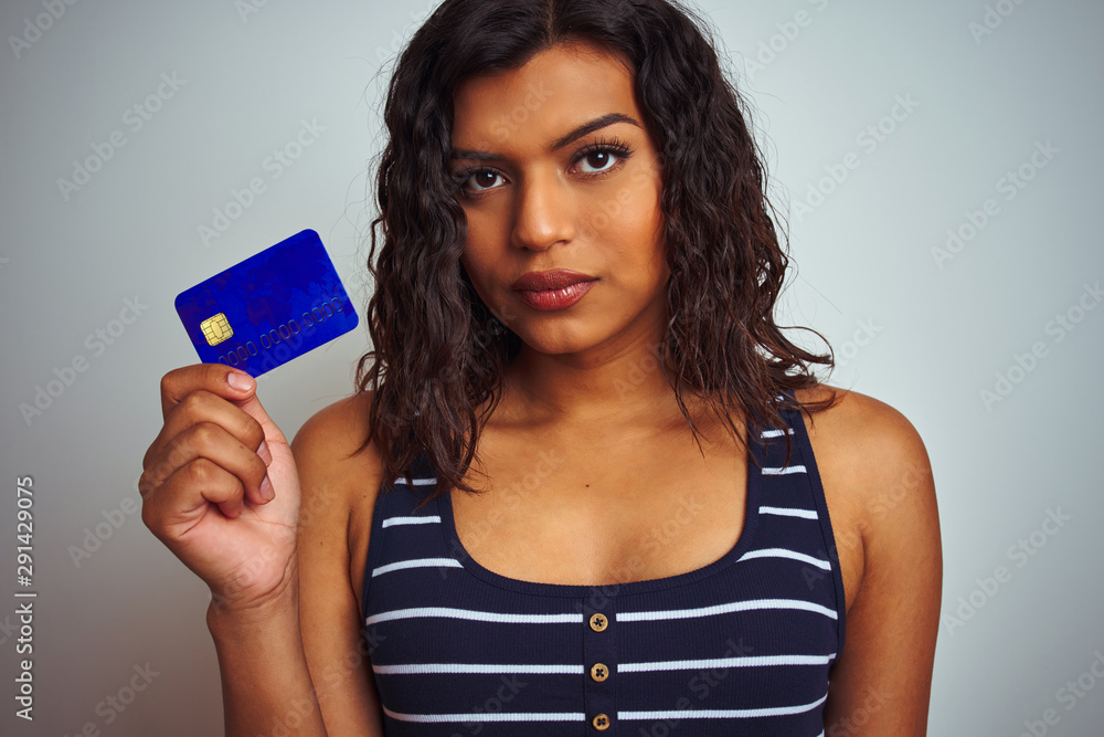 Transsexual transgender customer woman holding credit card over isolated white background with a confident expression on smart face thinking serious Transsexual transgender customer woman holding credit card over isolated white background with a confident expression on smart face thinking serious