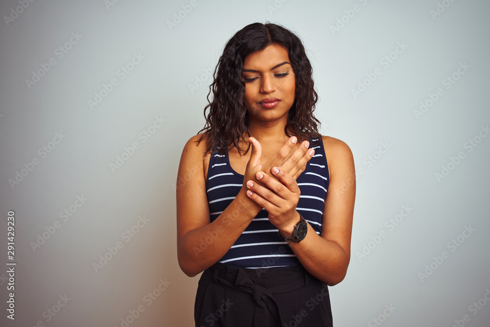 Transsexual transgender woman wearing striped t-shirt over isolated white background Suffering pain on hands and fingers, arthritis inflammation Transsexual transgender woman wearing striped t-shirt over isolated white background Suffering pain on hands and fingers, arthritis inflammation