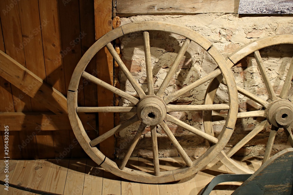 Old wooden wheels from grandfather's cart are stored in a rustic barn Old wooden wheels from grandfather's cart are stored in a rustic barn