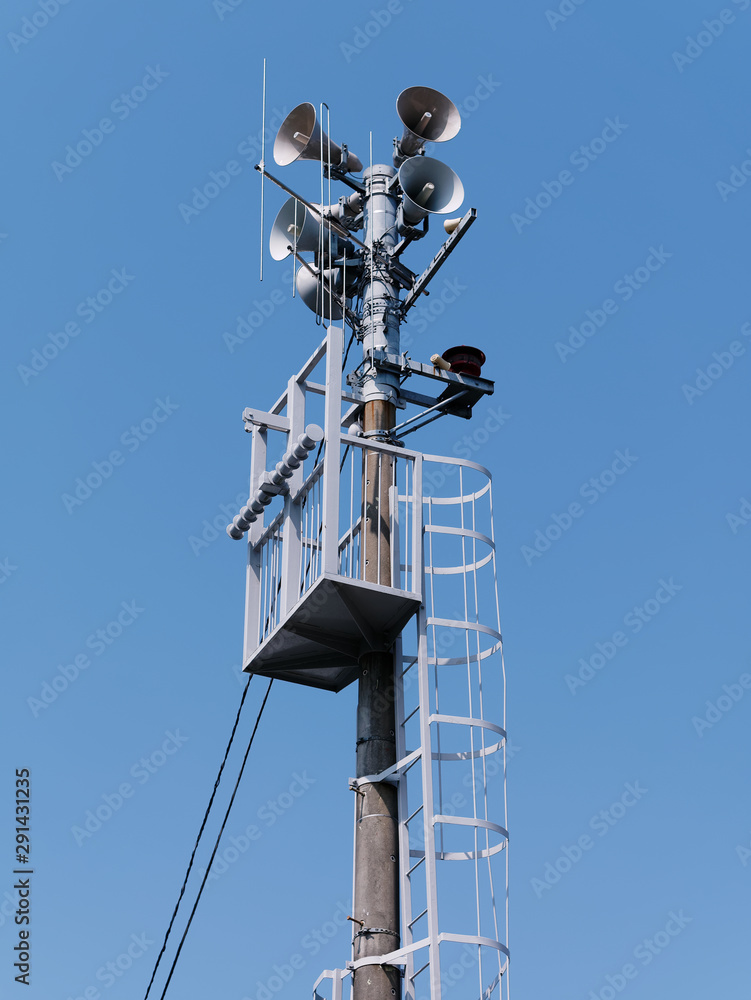 Low angle view of Emergency siren against blue sky background.