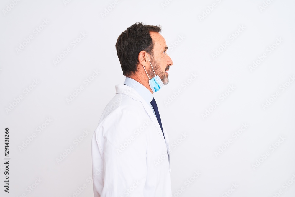 Middle age scientist man wearing coat and medical mask over isolated white background looking to side, relax profile pose with natural face with confident smile. Middle age scientist man wearing coat and medical mask over isolated white background looking to side, relax profile pose with natural face with confident smile.