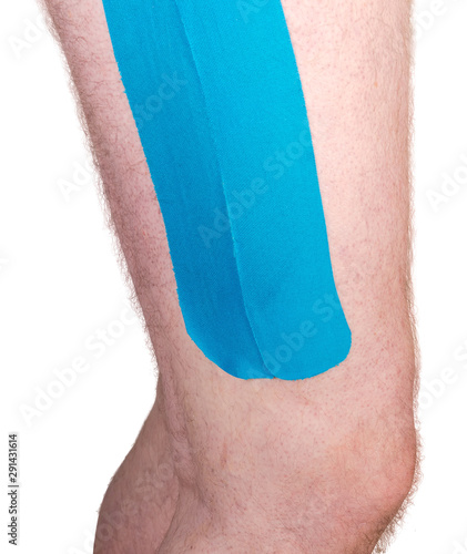 Blue elastic therapeutic tapes pasted on the male leg