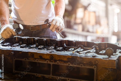 closed up of cylinder head and mechanic man holding valve and inspection cylinder head, Business and mechanic concept
