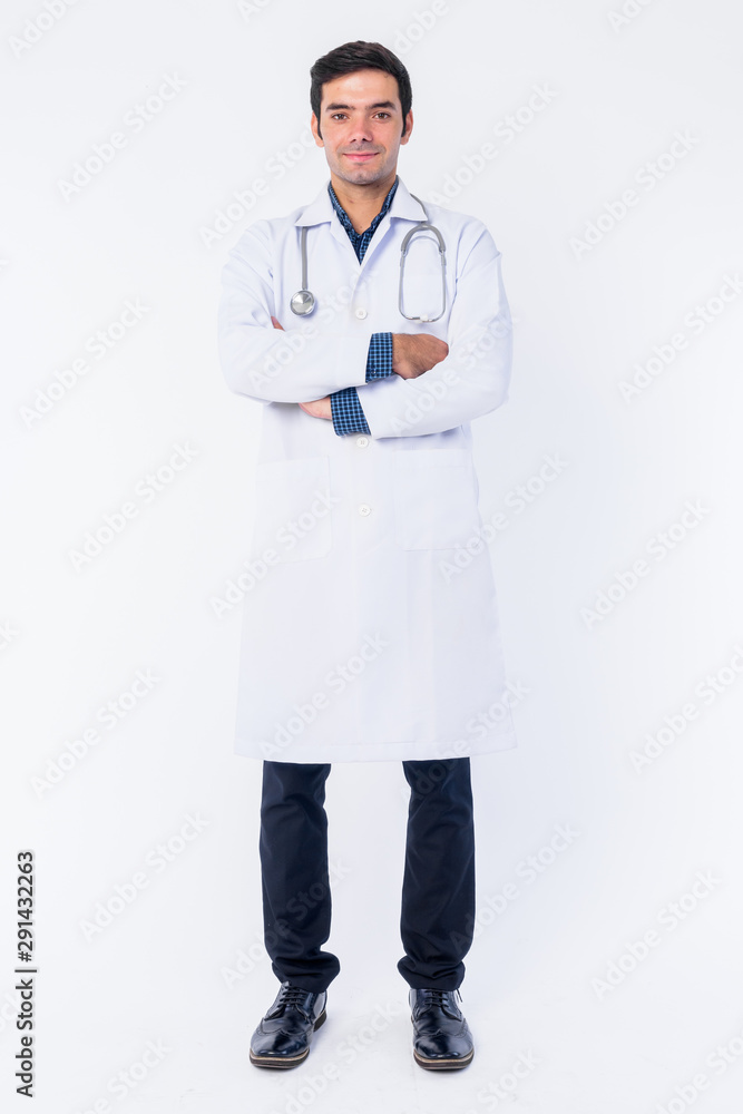 Full body shot of young Persian man doctor with arms crossed Full body shot of young Persian man doctor with arms crossed