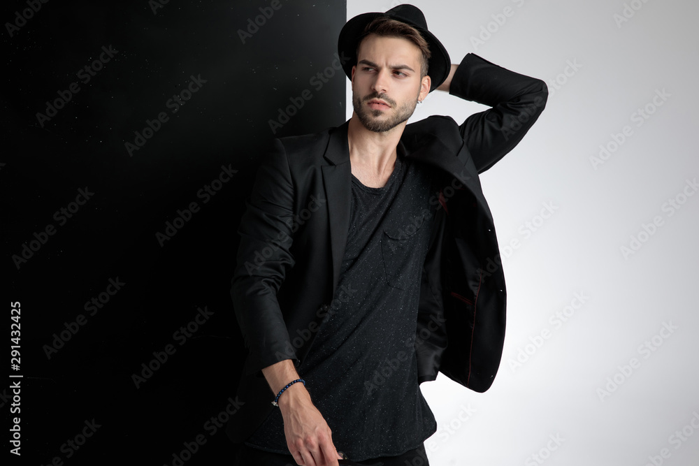 Fototapeta premium seductive young man holding hand to head in studio
