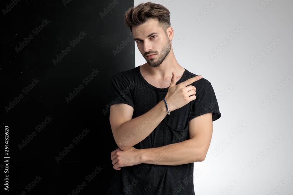 attractive smart casual man pointing finger in studio