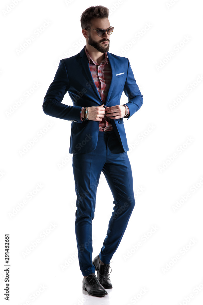 formal businessman in blue suit fixing coat formal businessman in blue suit fixing coat