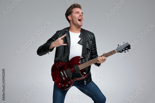 casual man playing his guitar passionate