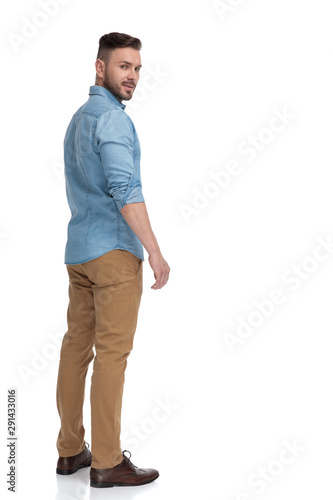 casual man standing and looking back over shoulder cool