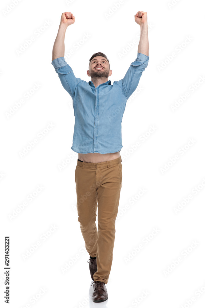 casual man walking with hands up in the air victorious