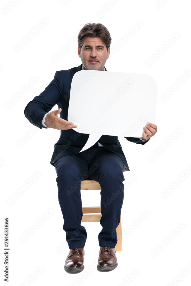 businessman sitting and presenting a speech bubble businessman sitting and presenting a speech bubble