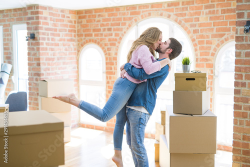 Young beautiful couple in love celebrating moving to a new home around cardboard boxes © Krakenimages.com