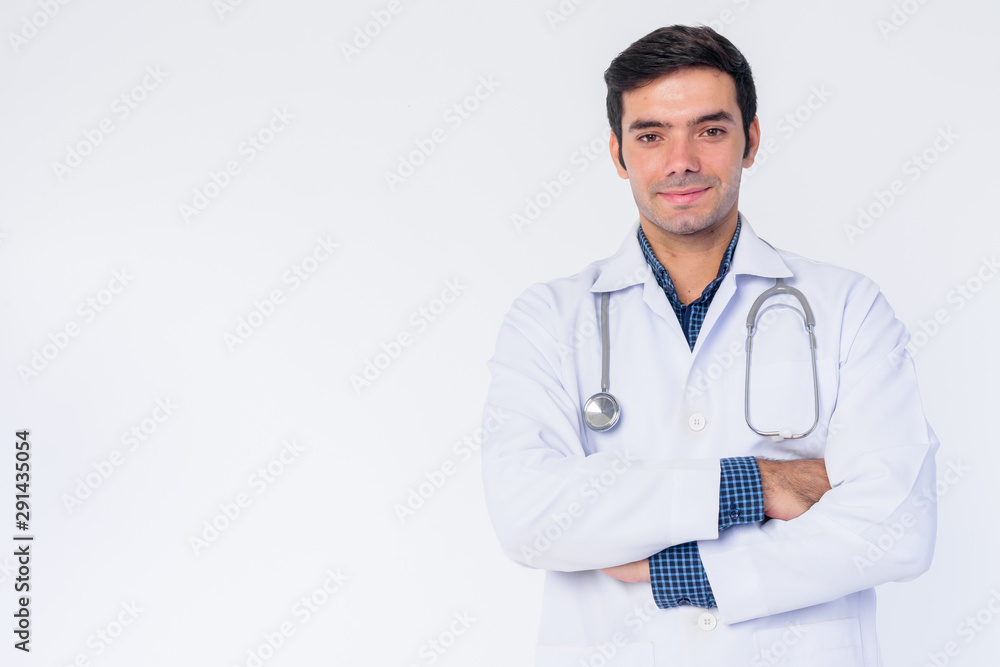 Portrait of happy young Persian man doctor smiling with arms crossed Portrait of happy young Persian man doctor smiling with arms crossed