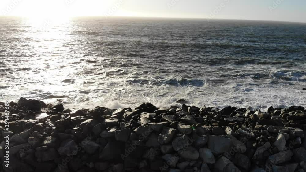 MB166_Following wave crashing onto a pile of rocks moving backwards going up showing stretch of piled rocks. Sunrise. MB166_Following wave crashing onto a pile of rocks moving backwards going up showing stretch of piled rocks. Sunrise.