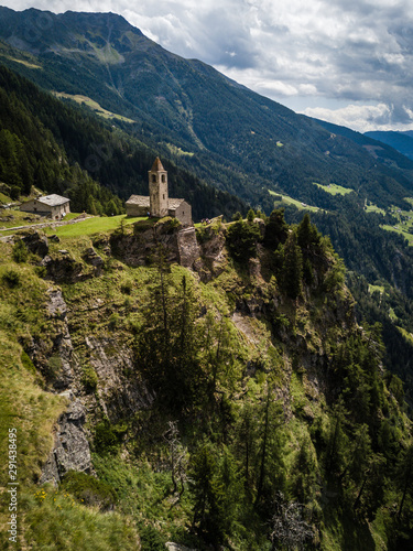 church/chapel close to cliff drop-off above mountain valley