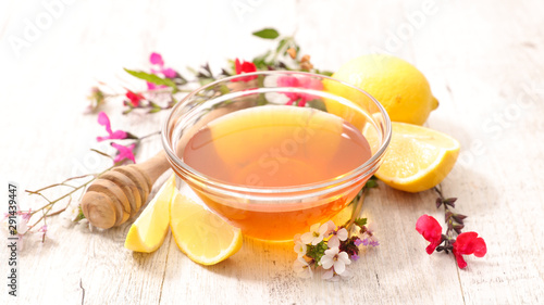 bowl of honey with lemon and flowers