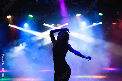 Silhouette of dancing girl against disco lights