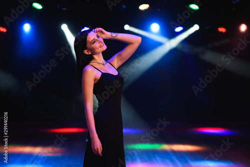 Beautiful sexy woman against the background of colored lamps.