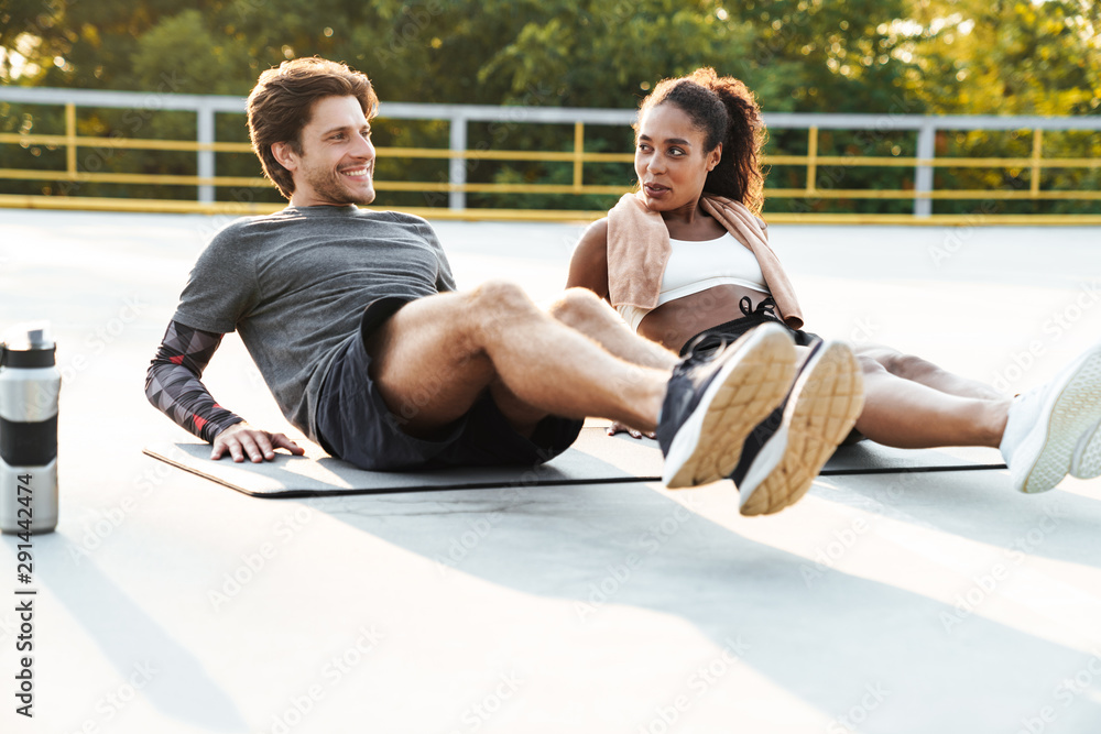 Obraz premium Photo of young cheerful couple doing exercise on mat