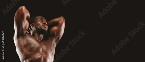 Charismatic fitness model with his hands behind head