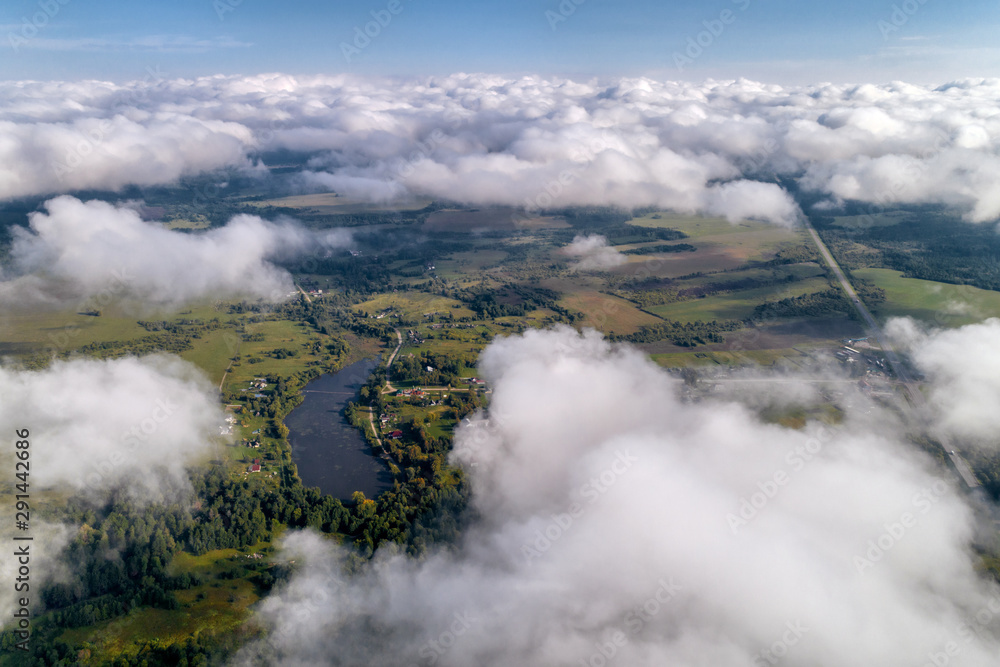 Fototapeta premium Beautiful views of the countryside from a great height. Flying above the clouds.