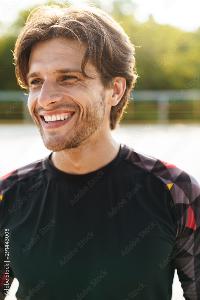Photo of young masculine man smiling while working out at playground Photo of young masculine man smiling while working out at playground
