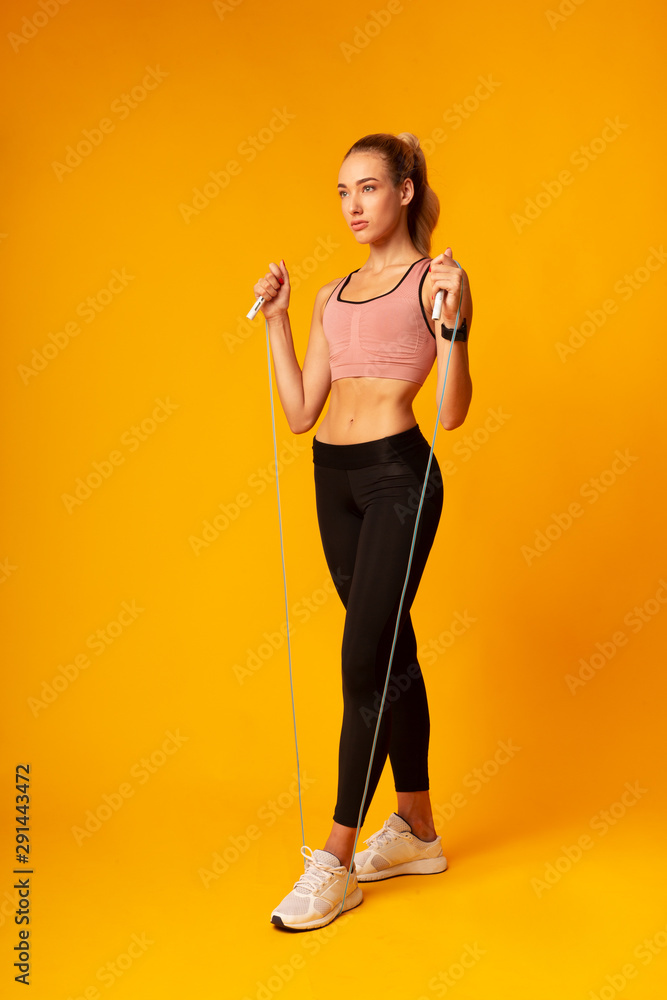 Young Lady Doing Jump Rope Exercise During Workout In Studio Young Lady Doing Jump Rope Exercise During Workout In Studio
