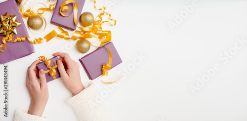 Close-up of female hands holding a present. Festive christmas background with copyspace. Top horizontal view