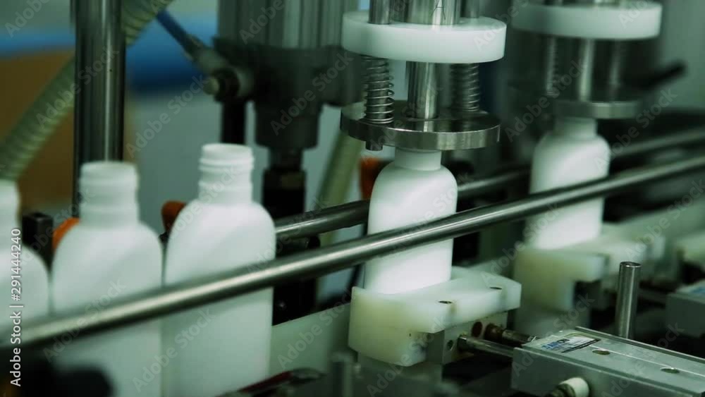 Cosmetics Manufacturing Plant. White Bottles On The Belt Conveyor. Shampoo Cosmetics Manufacturing Plant. White Bottles On The Belt Conveyor. Shampoo
