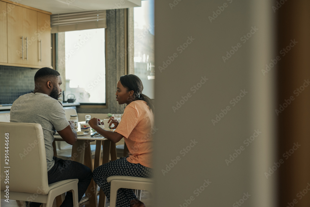 Young African American couple talking together over breakfast Young African American couple talking together over breakfast